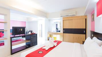 Una habitación de hotel moderna con cama, escritorio, televisor y armario.