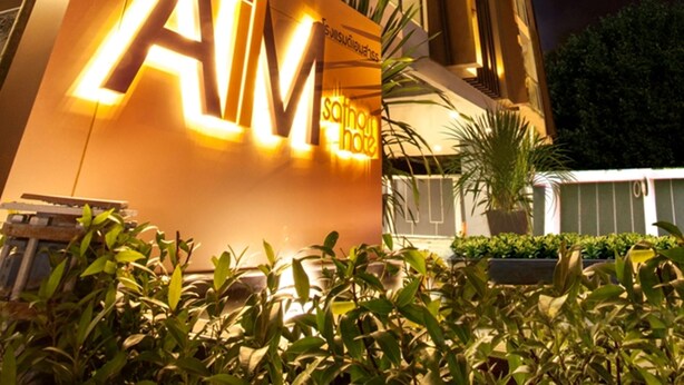 A modern building with illuminated signage reading "the AIM" and "SOUTHPOINT." - The Aim Sathorn Hotel (Bangkok)