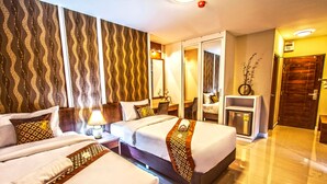 A hotel room with two beds, a mirror, a small table with a lamp, and a door leading to another room. - The Aim Sathorn Hotel (Bangkok)