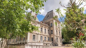 A classical building with a central staircase, a bridge, and a well-maintained garden. - Appart'City Confort Lyon Cité Internationale (Caluire-et-Cuire)