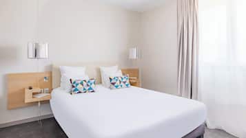 Een moderne hotelkamer met een groot bed, twee nachtkastjes, een houten hoofdbord en een groot raam met gordijnen.