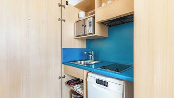 A compact kitchen with a built-in microwave, a sink, and a dishwasher.