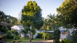 A residential area with a curved driveway, surrounded by lush greenery and white houses. - Kidd Street Cottages (Tamborine Mountain)