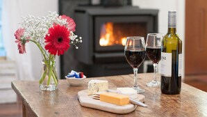 A wooden table with cheese, wine, and flowers. - Kidd Street Cottages (Tamborine Mountain)