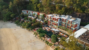 Un hotel con varias plantas, piscina y playa.