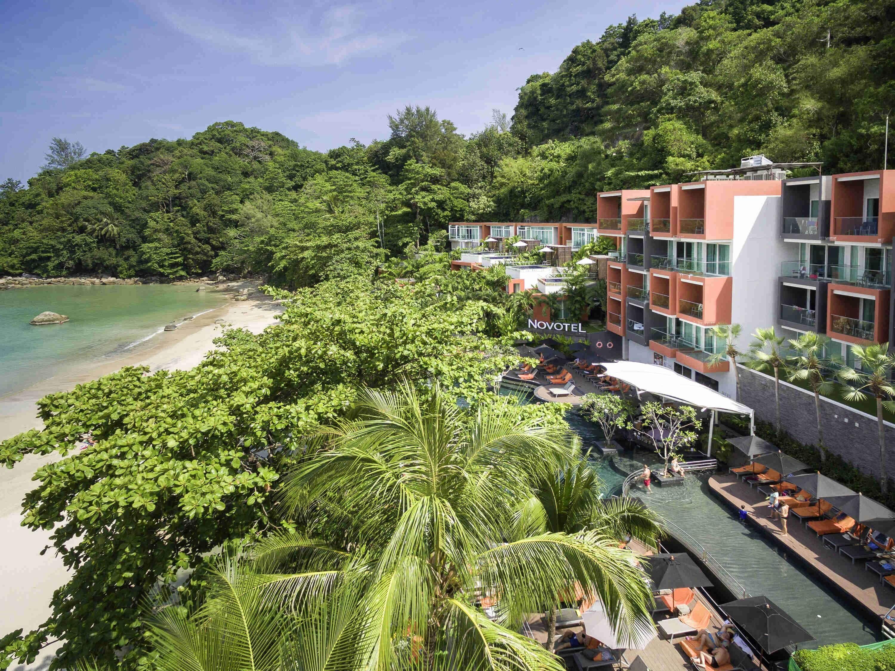 A hotel with a pool area, outdoor seating, and a view of the beach.