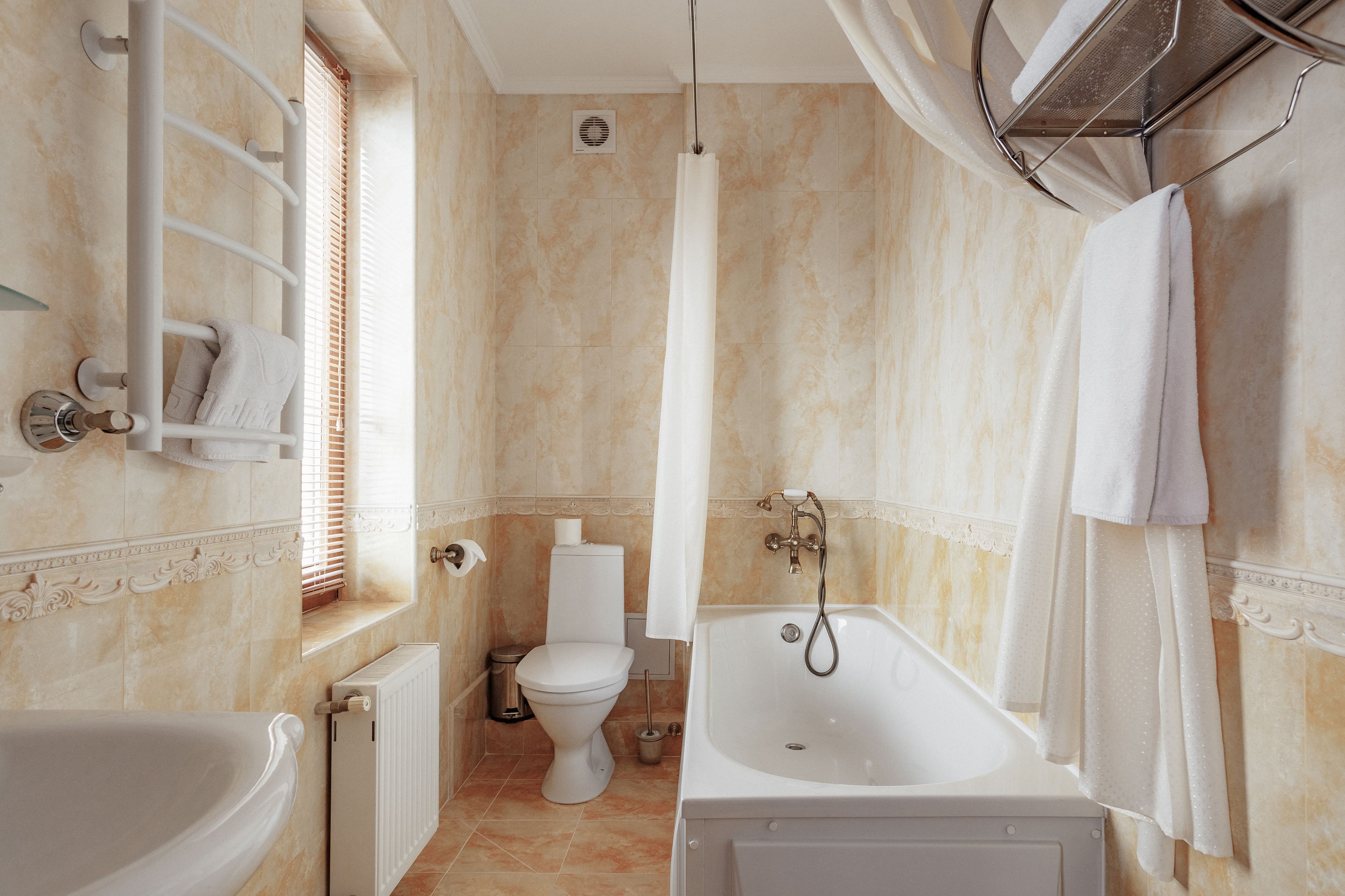 A bathroom with a bathtub, toilet, and shower curtain.