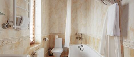 A bathroom with a bathtub, toilet, and shower curtain.