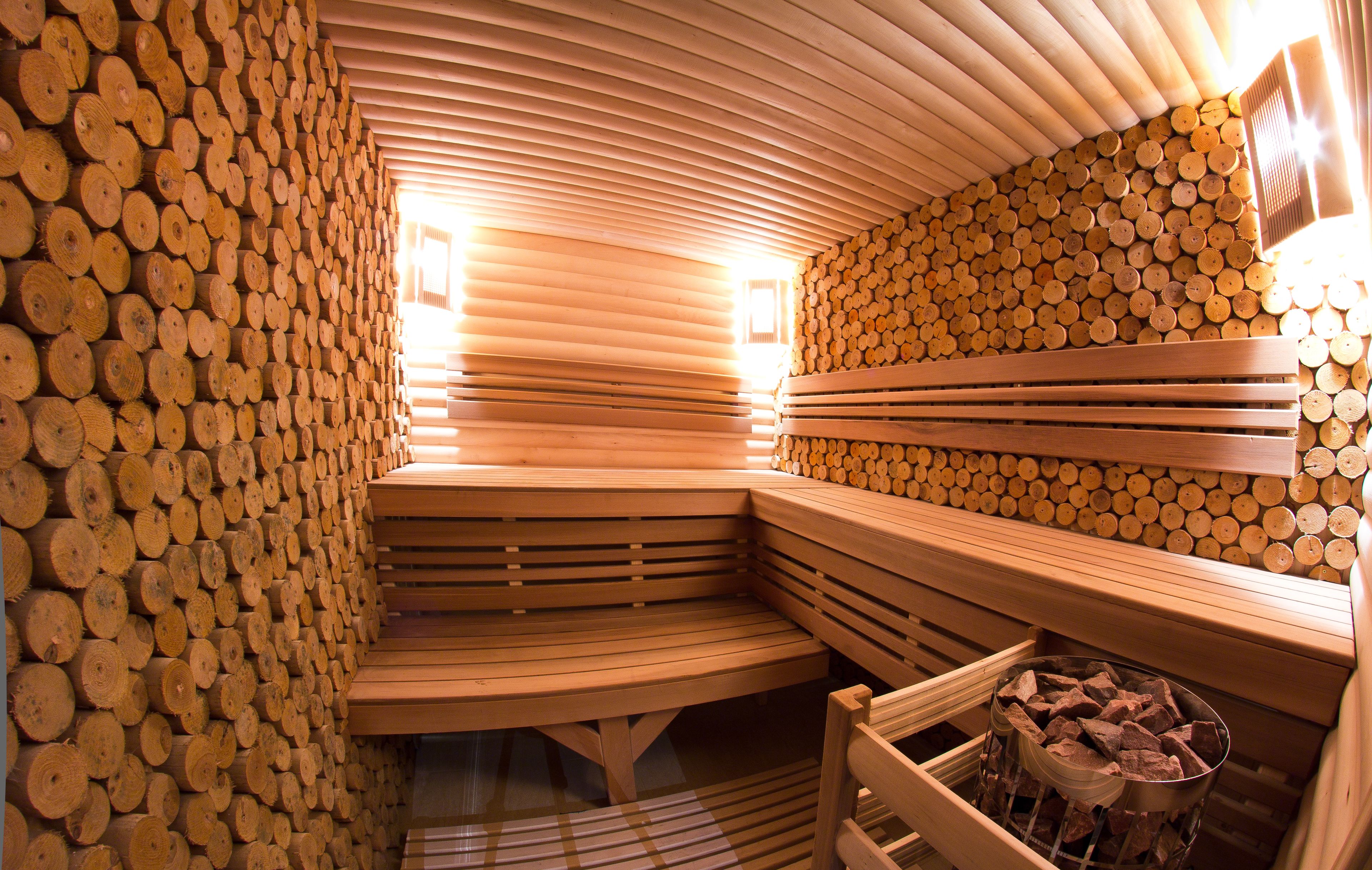 Una sauna con bancos de madera y paredes revestidas de troncos.