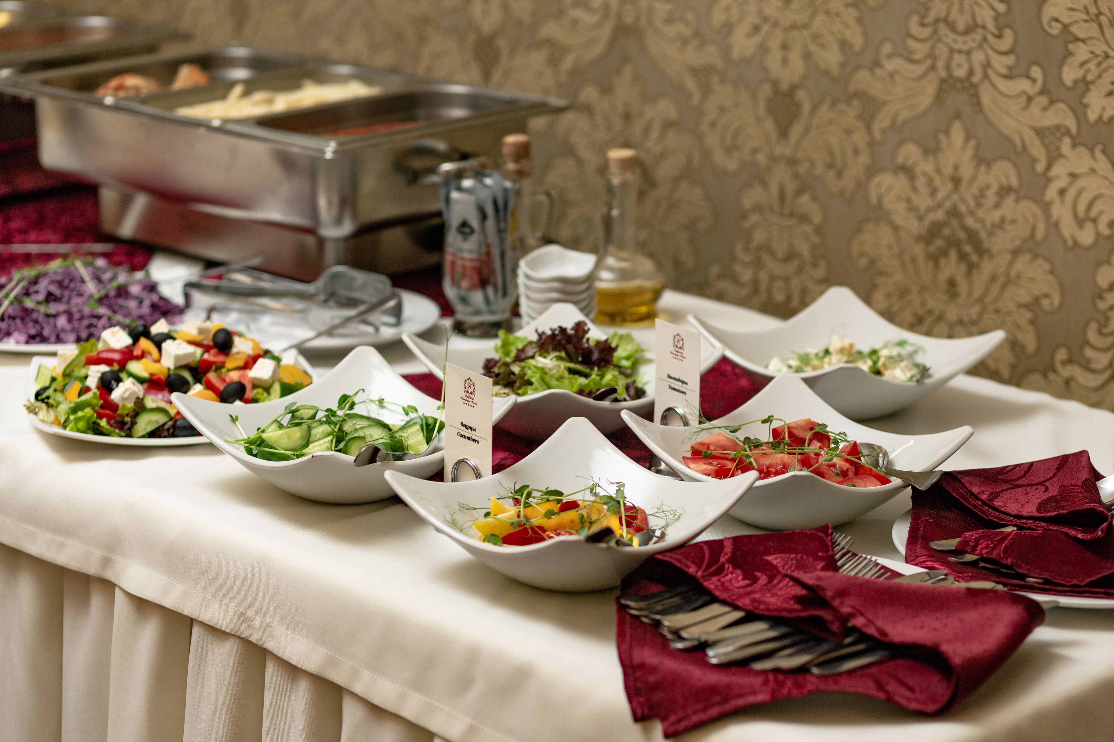 Uma mesa de buffet com diversas saladas e uma seleção de bebidas.