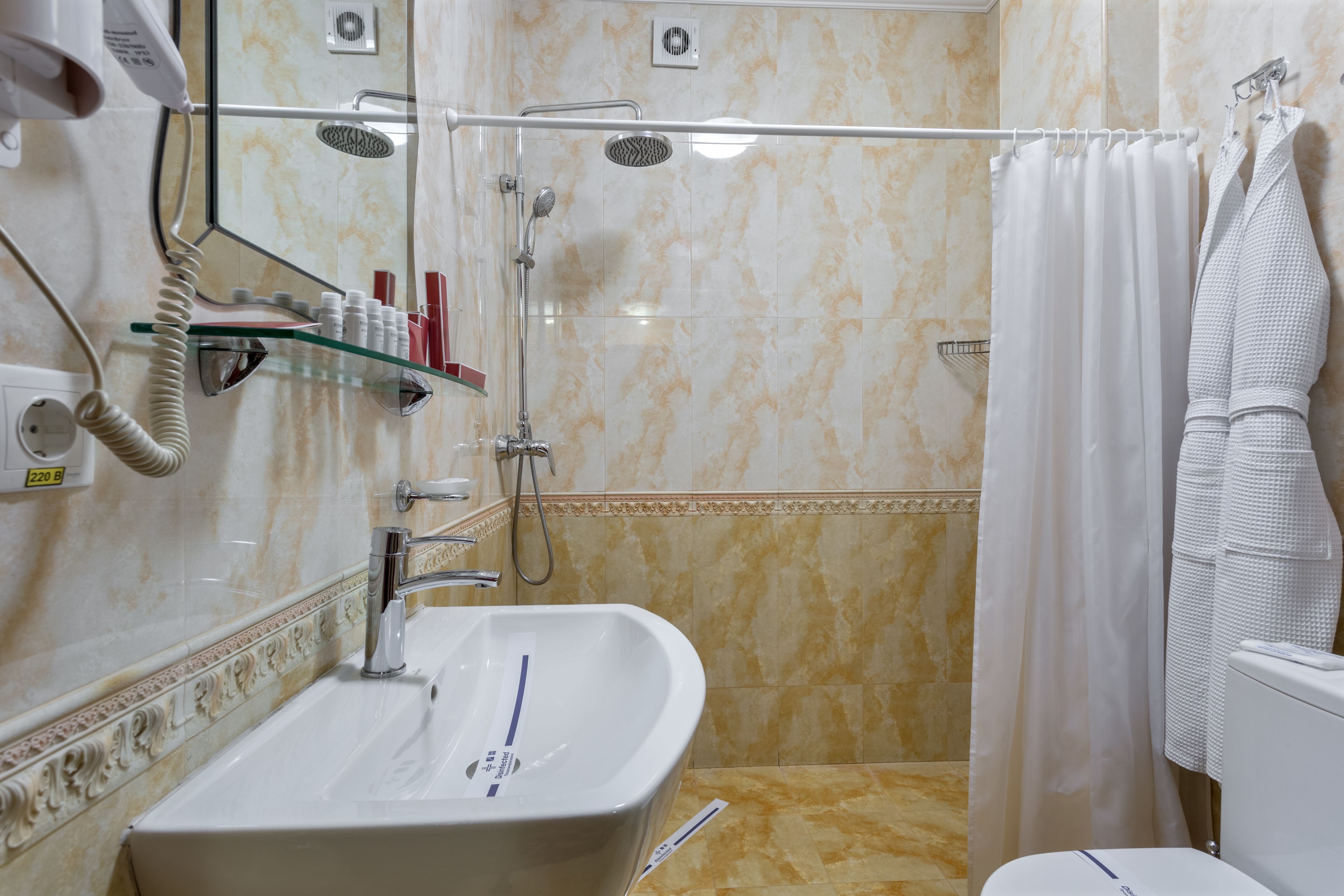 A bathroom with a sink, shower, and toilet.