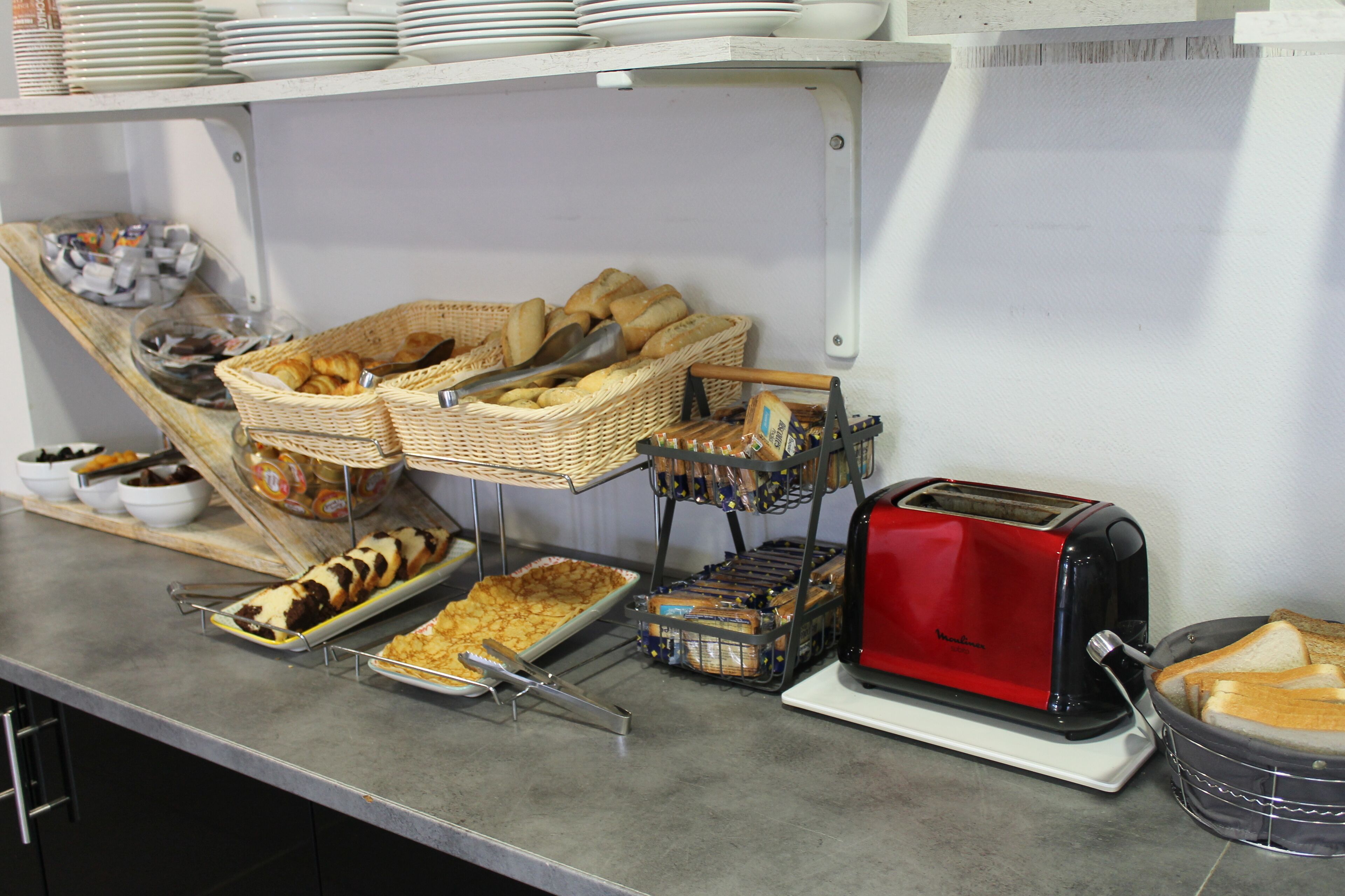 Un bufé con diversos alimentos y un tostador.