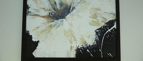 A framed abstract painting with a central burst of white and black colors.