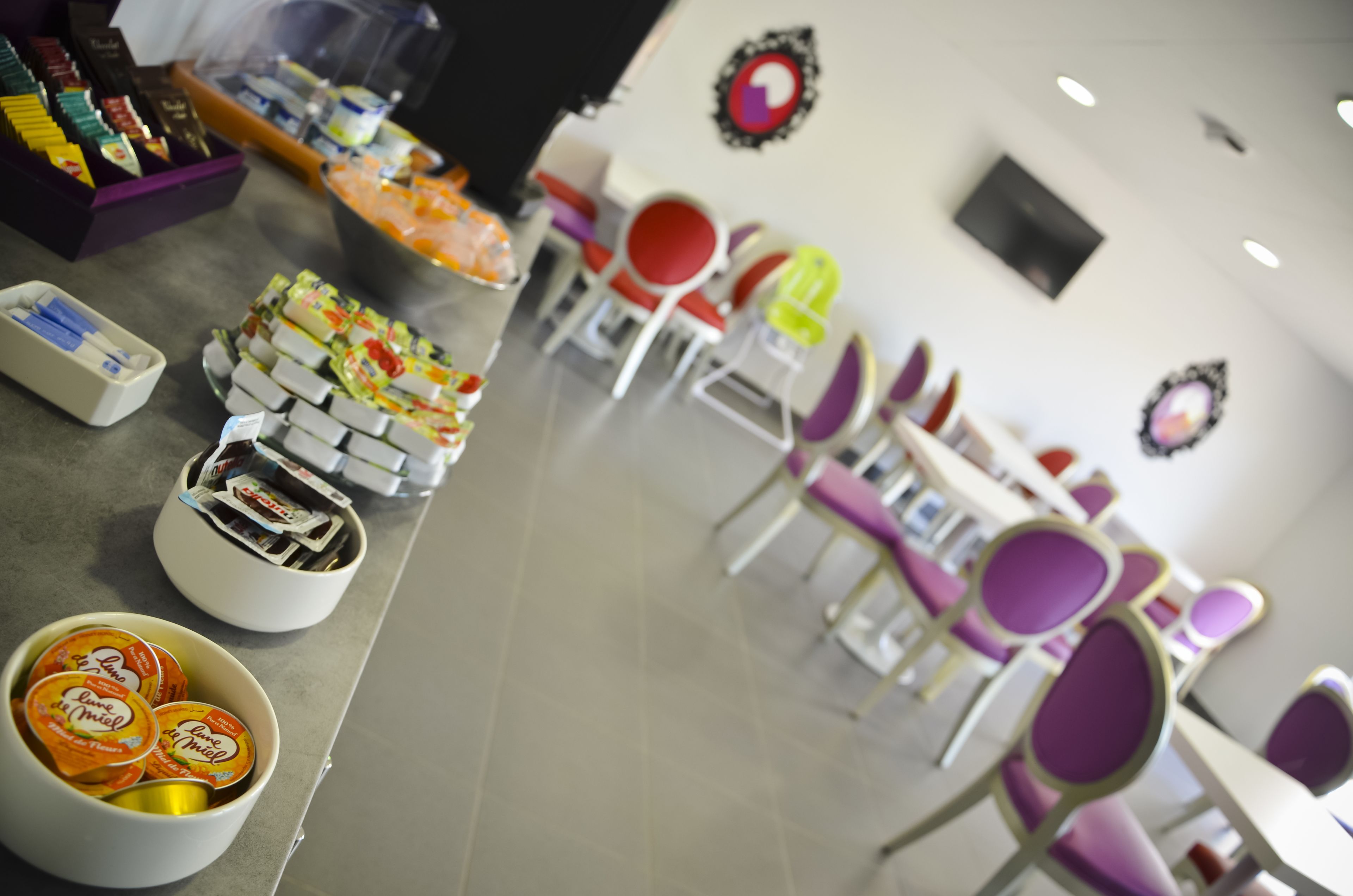 Un área de cafetería con diferentes opciones de comida y un espacio de estar.