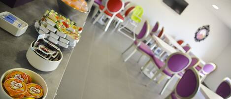 Un área de cafetería con diferentes opciones de comida y un espacio de estar.