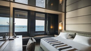 A hotel room with a large bed, a desk, and a view of the sea. - Key Hotel - Boutique Class (Izmir)