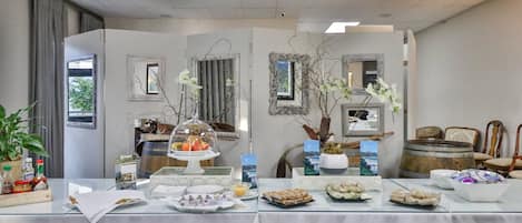 A buffet table with various food items and a decorative centerpiece.