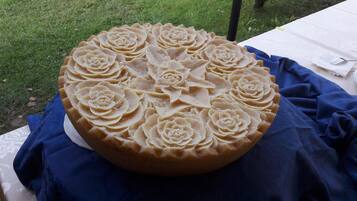 A cake with intricate floral designs on a table covered with a blue cloth.