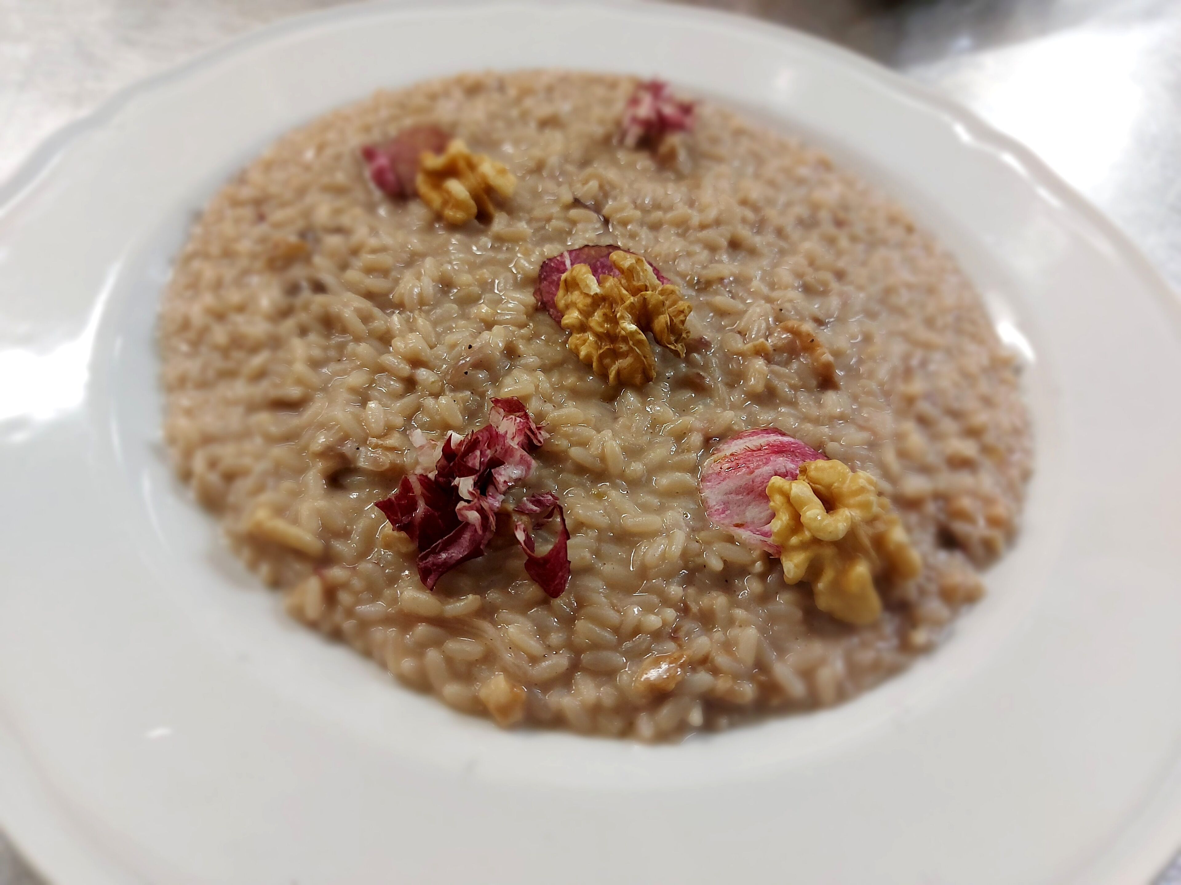 A plate of oatmeal with raisins and nuts.