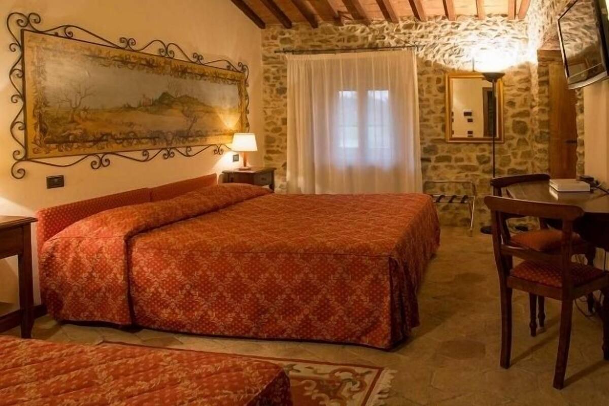 Une chambre confortable avec un grand lit, une petite table et une chaise.