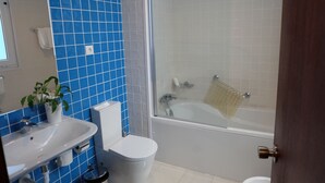 A bathroom with a white sink, toilet, and bathtub.