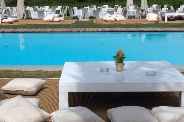 Alberca al aire libre, sombrillas en la alberca y camastros 