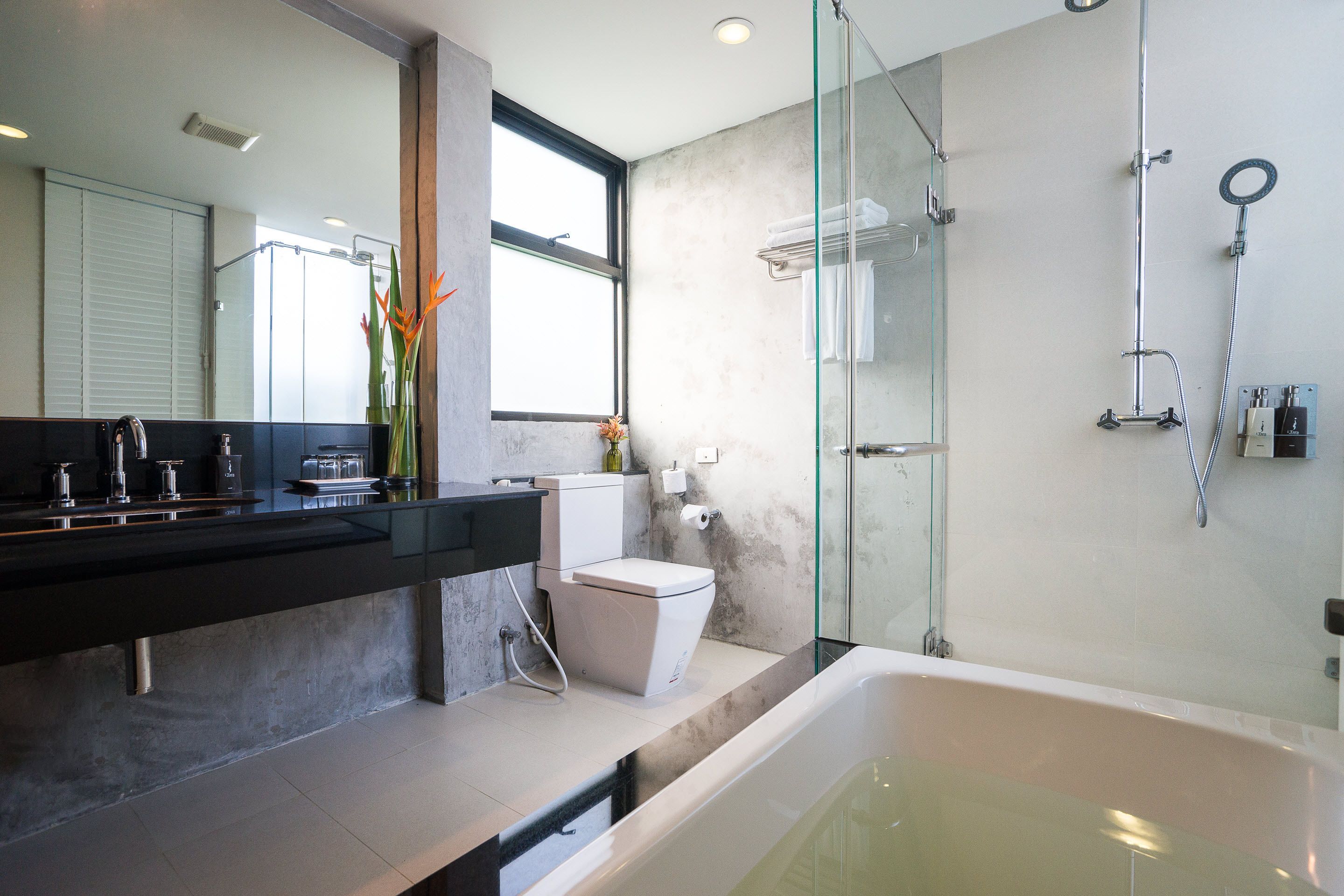 Un baño moderno con ducha acristalada, bañera y retrete.