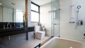 Un baño moderno con ducha acristalada, bañera y retrete.
