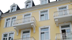 A multi-story building with ornate balconies, large windows, and a grand entrance with steps and a railing. - Milbor Hotel (Bad Soden am Taunus)