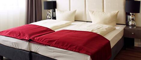 A hotel room with a large bed, two bedside tables, and a modern headboard.