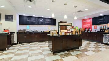 A cafe with a checkered floor, a chalkboard menu, and a red waffle sign.