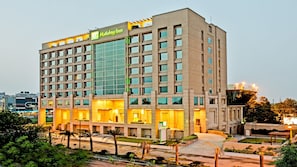 A multi-story Holiday Inn hotel with a modern design, featuring a prominent glass facade and a well-lit entrance. - Holiday Inn Amritsar Ranjit Avenue by IHG (Amritsar)