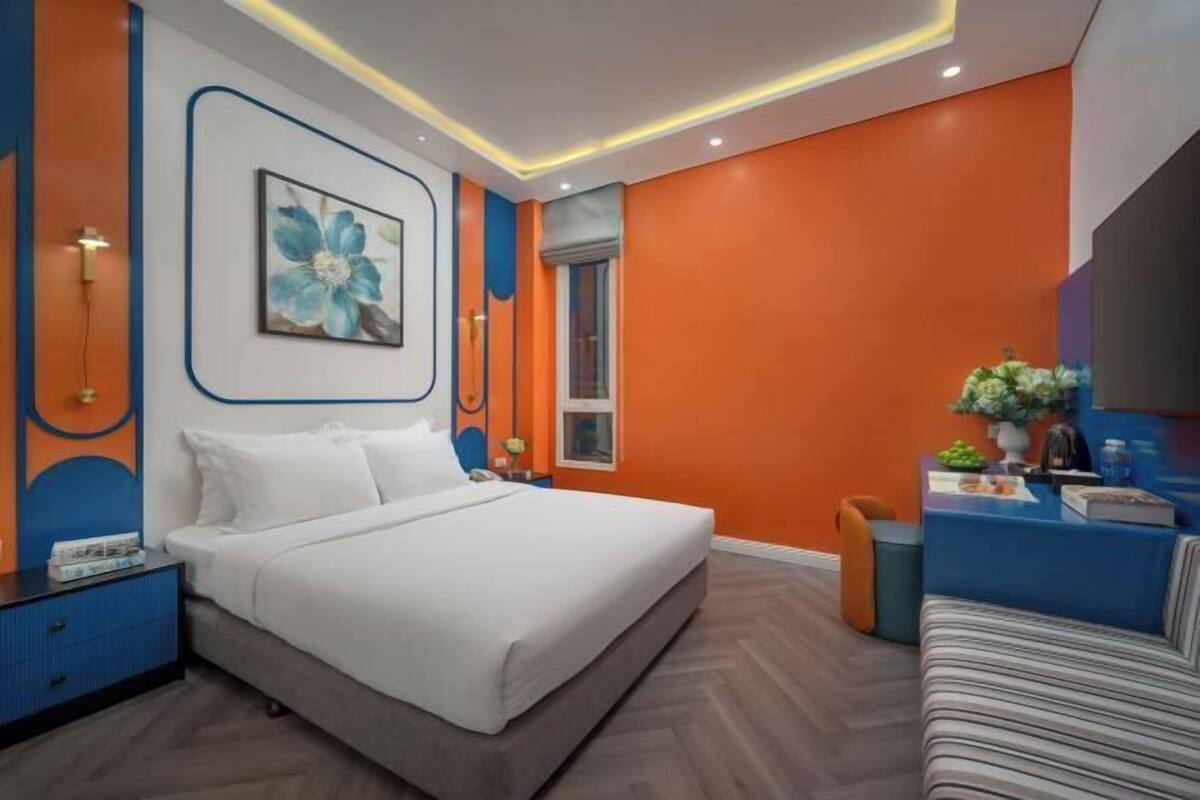 Une chambre moderne comprenant un lit, une table de chevet et un coin salon avec un canapé.