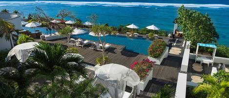 Relax by the large pool surrounded by sun loungers and umbrellas, with breathtaking ocean views.