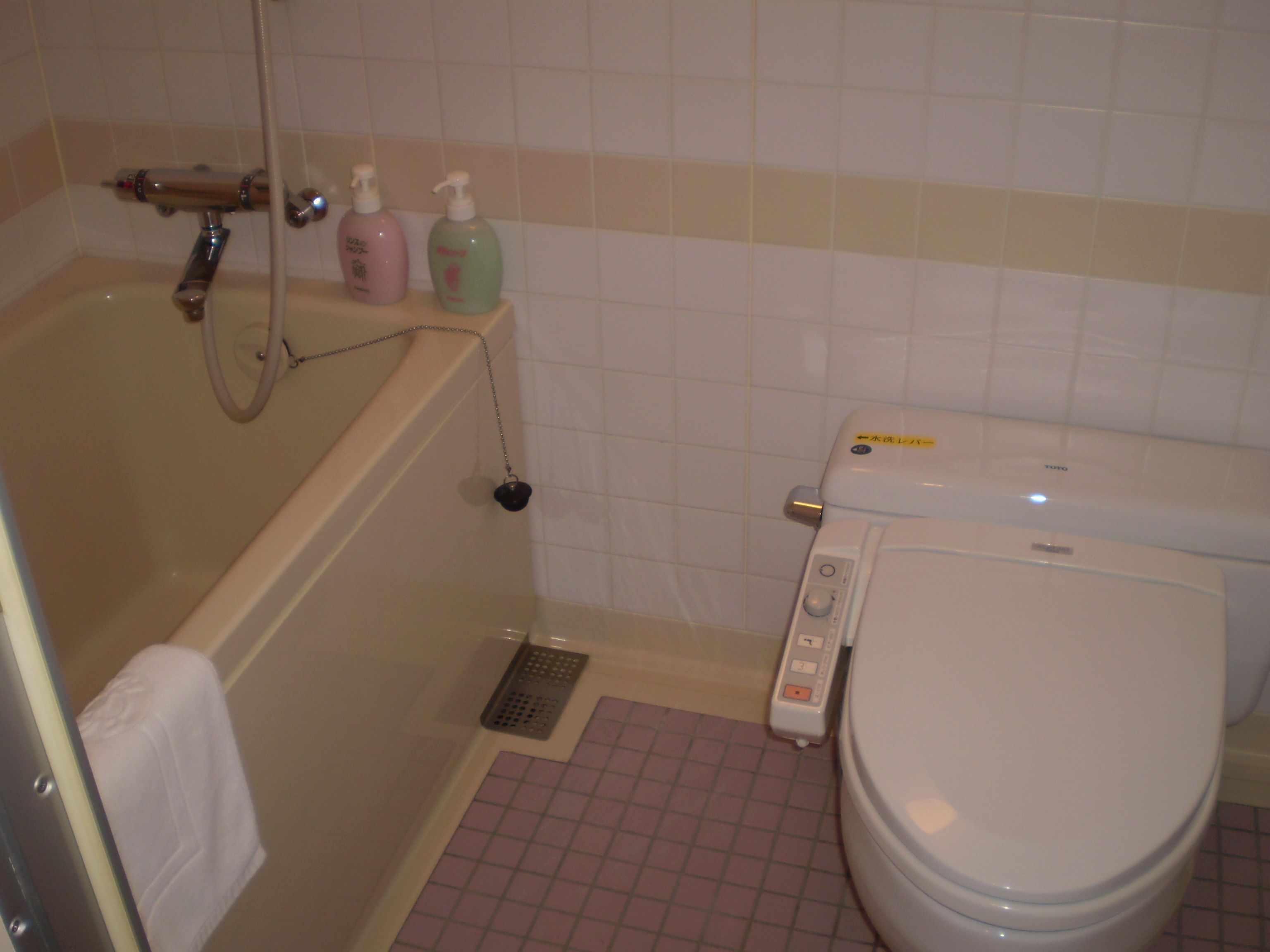 A bathroom with a bathtub, toilet, and shower.