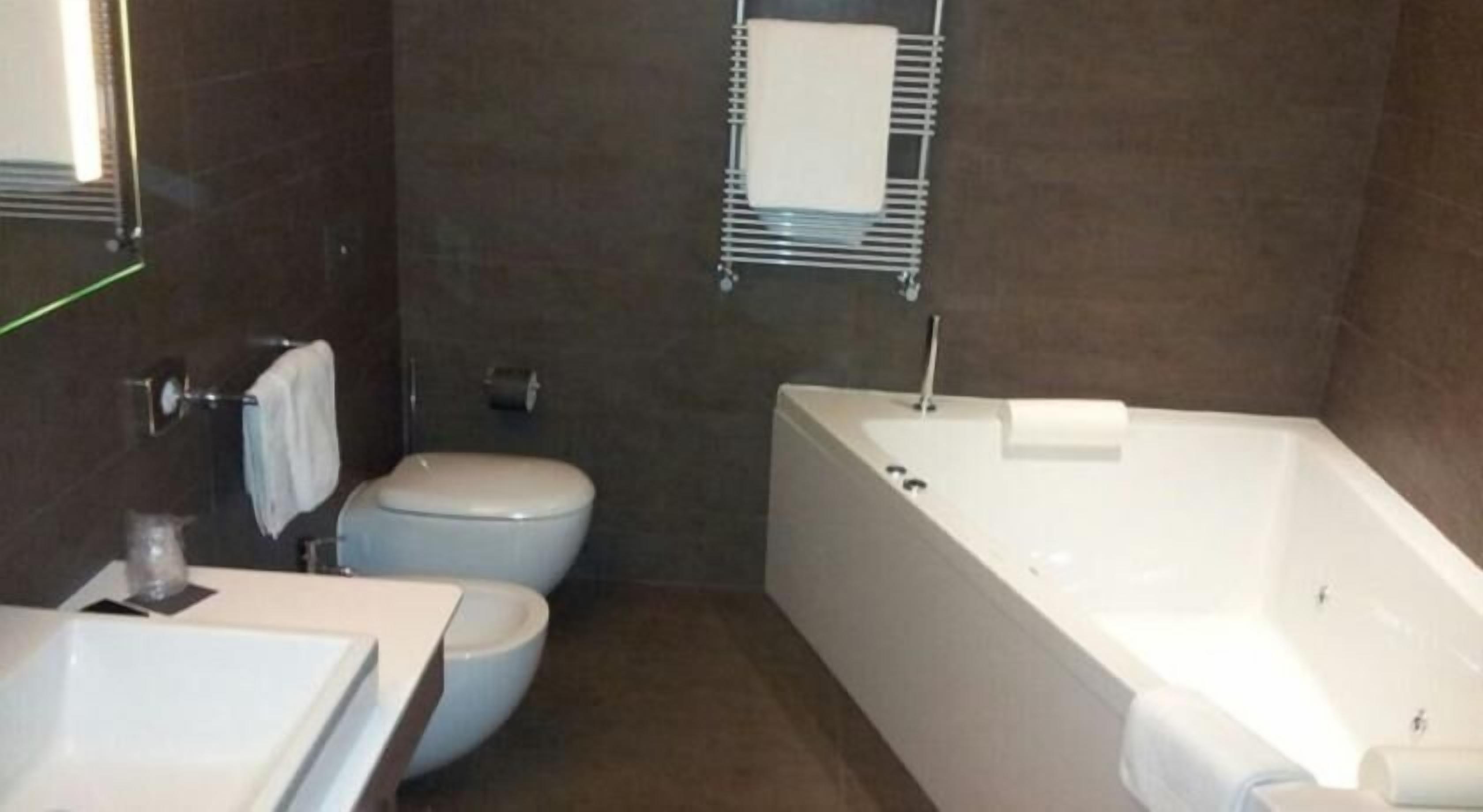 Un baño con lavamanos, inodoro y bañera blancos.