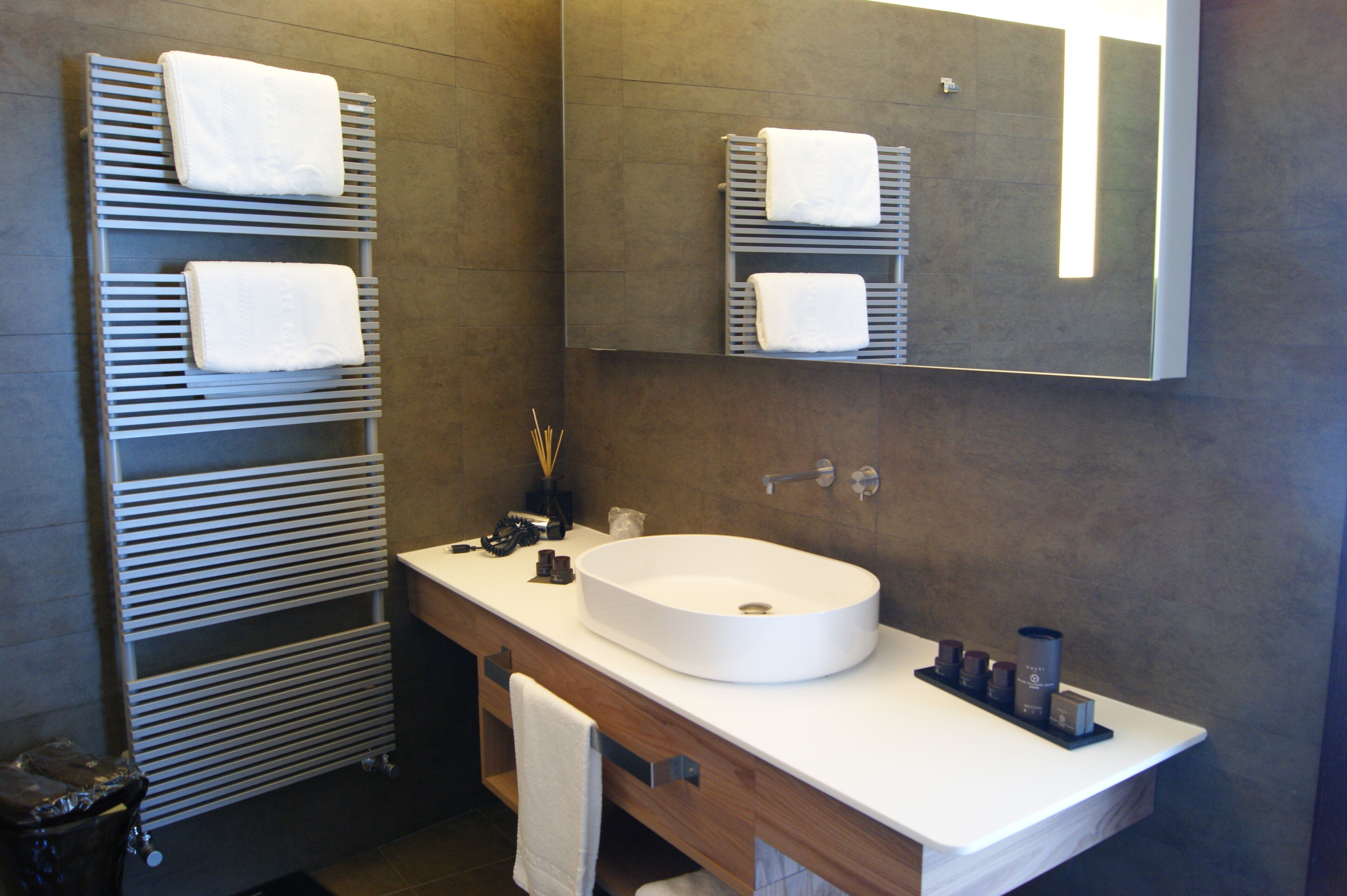 A modern bathroom with a built-in sink, towel racks, and a mirror.