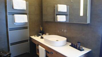 A modern bathroom with a built-in sink, towel racks, and a mirror.