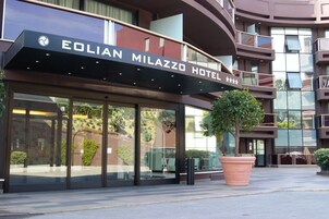 Exterior del HOTEL EOLIAN MILAZZO con un gran árbol en maceta al frente.