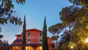 A large, multi-story building with a red facade, arched windows, and a central courtyard. - Resort La Rocchetta (Rome)
