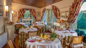 A dining area with tables set for breakfast, featuring a variety of dishes and drinks. - Resort La Rocchetta (Rome)