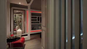 A modern interior with a red sofa, a white table, and a bookshelf with decorative items. - Luxury on the River (Rome)