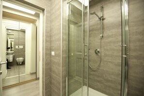 A modern bathroom with a glass-enclosed shower, a visible toilet, and a sink. - Luxury on the River (Rome)