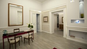 A room with a dining table, chairs, a large mirror, and a wall-mounted shelf with decorative items. - Luxury on the River (Rome)