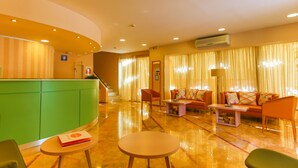 A hotel lobby with a reception desk, a sofa set, and a coffee table. - Rodian Gallery Hotel Apartments (Rhodes)