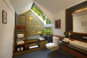 Un baño moderno con tragaluz, ducha, inodoro y lavabo.