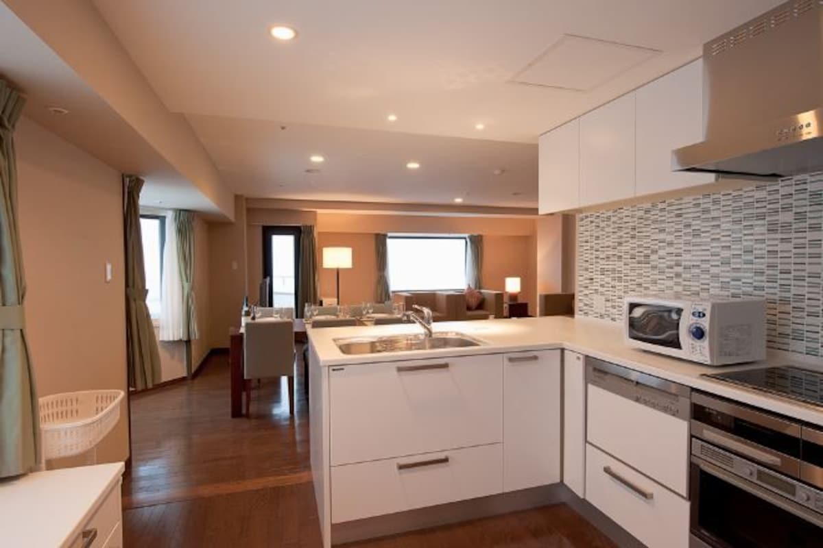 A modern kitchen with white cabinetry, a microwave, and a dishwasher.