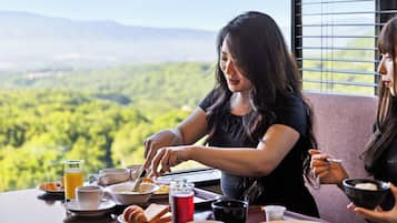 A dining table with breakfast items and a scenic view.