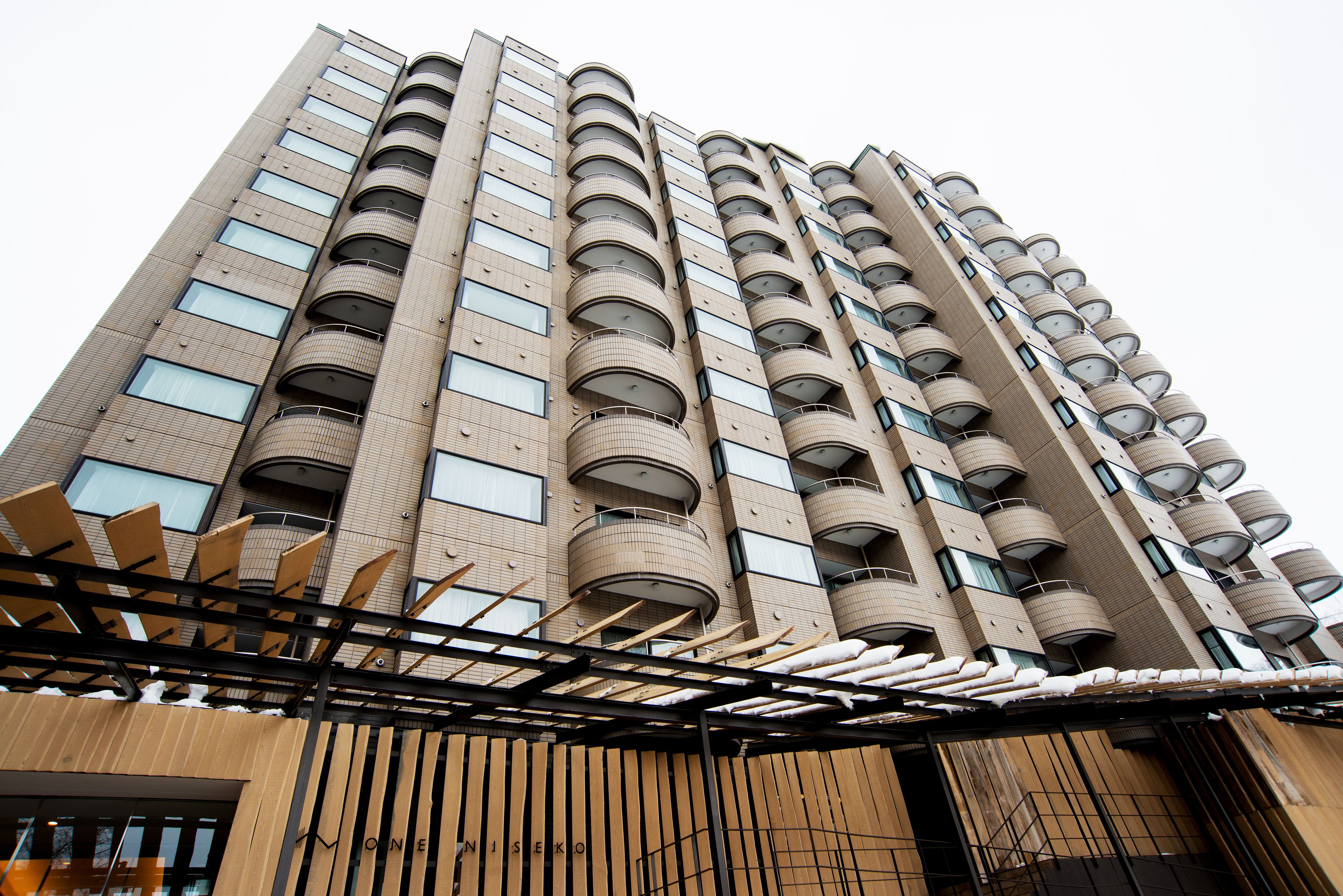 A high-rise building with multiple balconies and a modern architectural design.