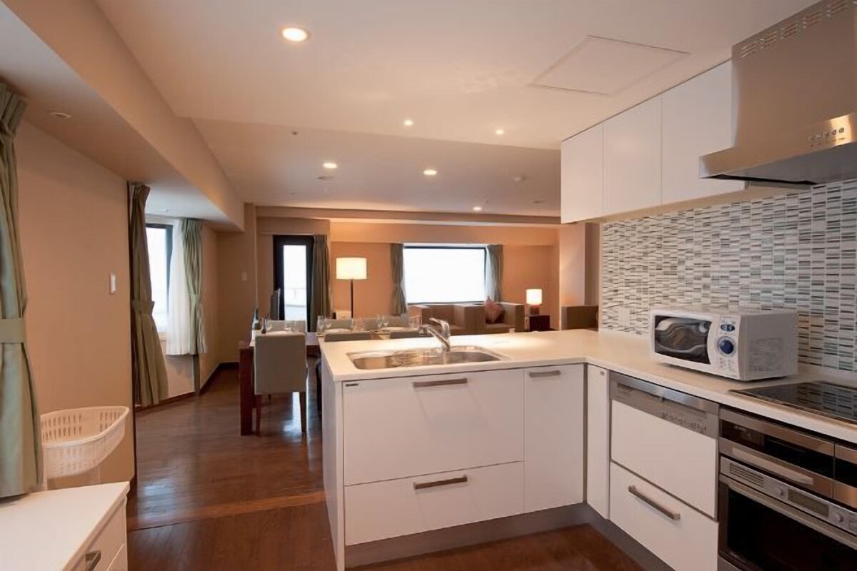 A modern kitchen with white cabinetry, a microwave, and a dishwasher.